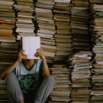 A person reading a book surrounded by tons of books - one percent readers